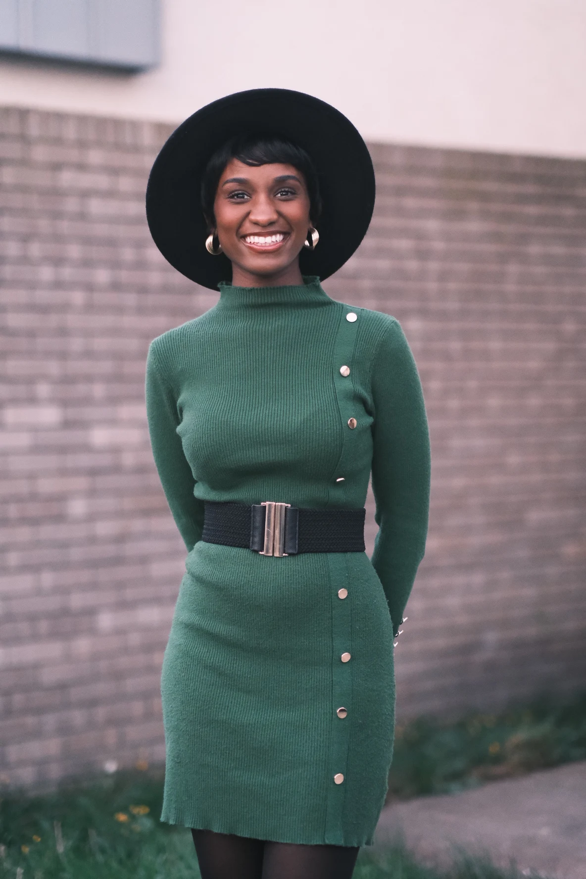 Elizabeth Zion in a green dress and black hat outdoors